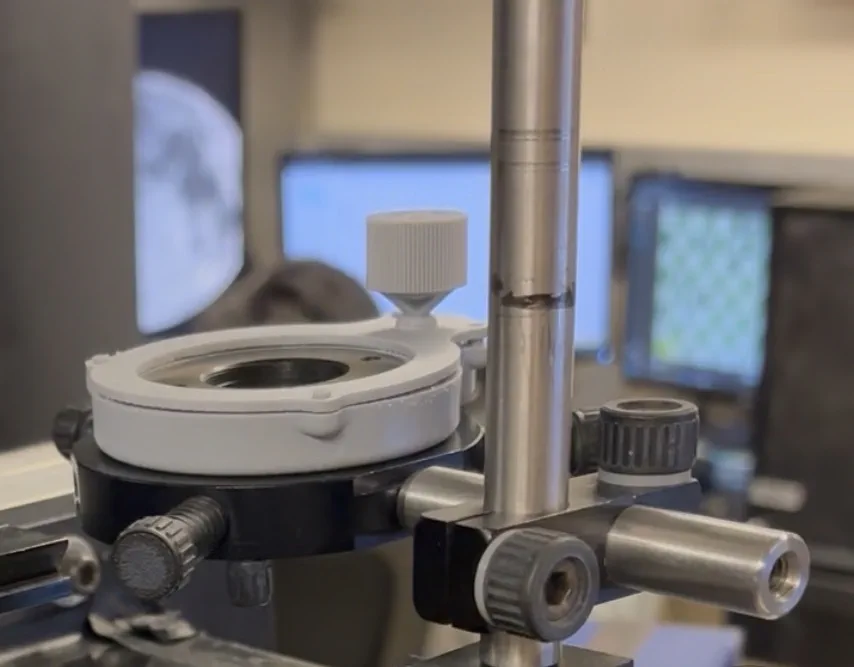 White 3D-printed ring holder with one knurled knob, mounted on a black base on a metal post.