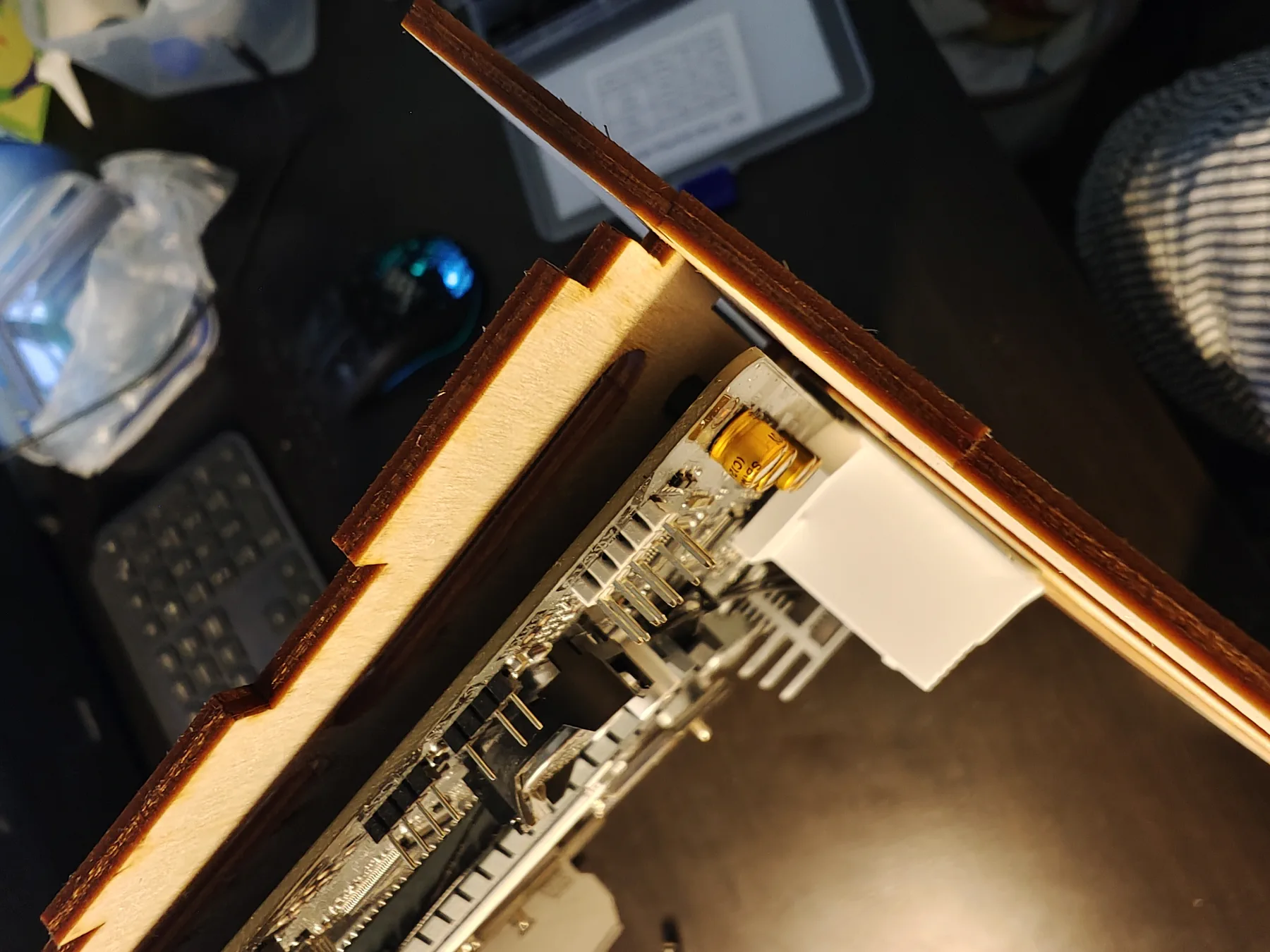 Close-up of plywood panel joints next to the edge of a motherboard.