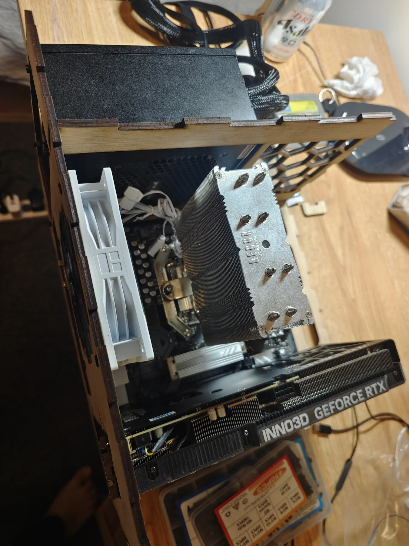 Plywood PC frame holding a power supply, a large CPU cooler and a graphics card.