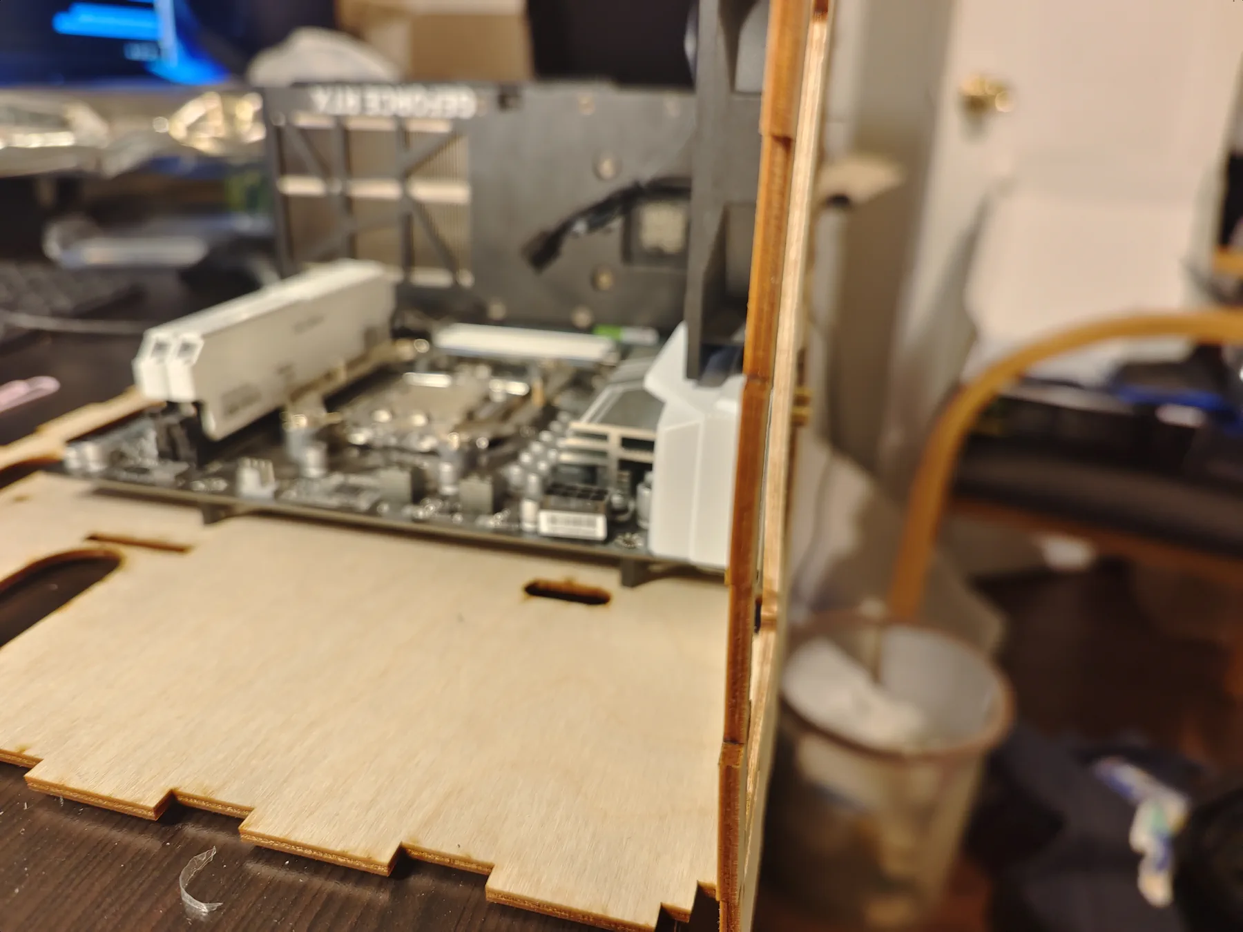 Motherboard and graphics card sitting on a laser-cut plywood panel.
