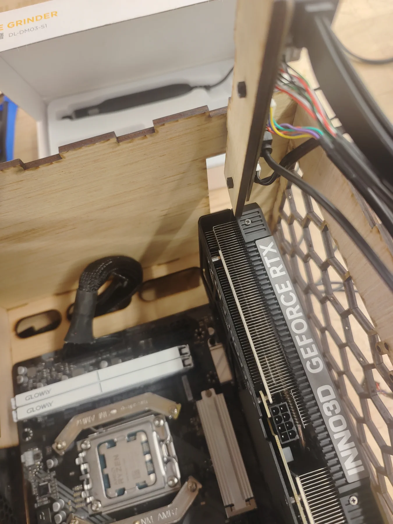 Interior of a plywood PC case showing a CPU socket, RAM and a graphics card.